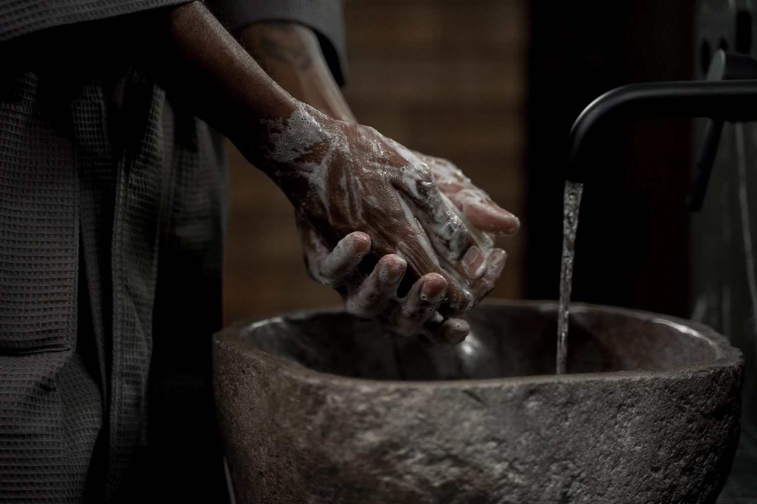 hands covered in soap next to sink